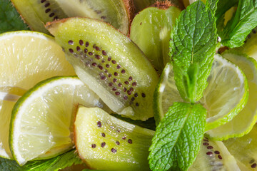 beautiful slicing of juicy fresh fruits - lime, kiwi, a sprig of mint