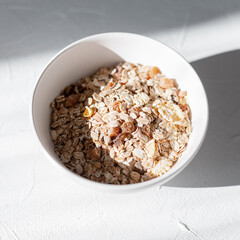 Raw healthy breakfast with oatmeal and candied fruits at the sunlight in the morning