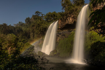 twin water drops in Cataratas del Iguazú National Park, called Sister junps (Salto dos hermanas) between the jungle forest in Iguazú, Misiones, Argentina with a rainbow.

