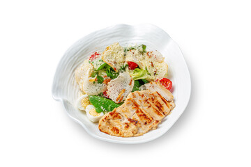 A Caesar salad with chicken breast, croutons, boiled eggs, cherry tomatoes, spinach greens and cabbage leaf sprinkled with cheese on a plate on a white isolated background