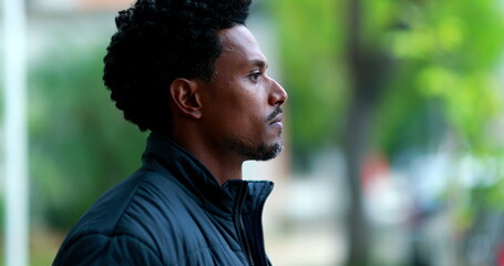 Pensive black african man smoking cigarette outdoors