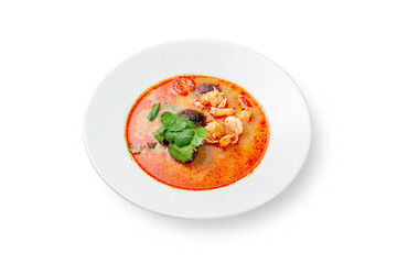Creamy white wine soup with tiger shrimp, salmon, green onions and cherry tomatoes in a plate on a white isolated background. Thai Tom Yam soup with shrimp and shiitake mushrooms