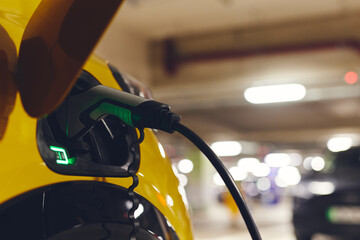 Plugged in electric car charging in mall car park