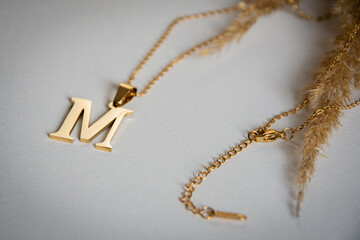 Fototapeta na wymiar gold M necklace