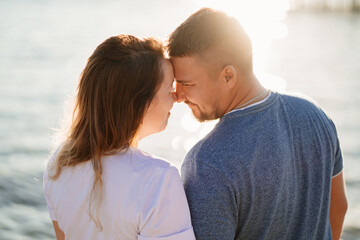 profiles couple in love kissing on the sea beach. solar glare