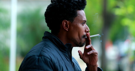 Candid African american smoking cigarette outside