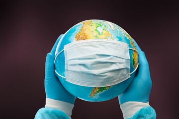 COVID. New strain of coronavirus. Face mask on the globe,