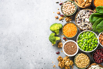Vegan protein source. Legumes, beans, lentils, nuts, broccoli, spinach and seeds. Top view on stone table. Healthy vegetarian food.