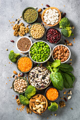 Vegan protein source. Legumes, beans, lentils, nuts, broccoli, spinach and seeds. Top view on stone table. Healthy vegetarian food.