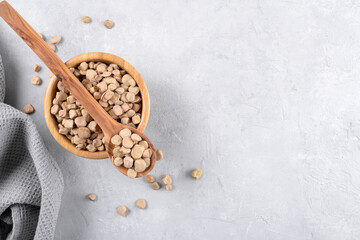 Cicerchia or indian pea in a wooden bowl and spoon on grey table background, gluten free food....