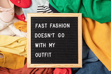 Fast fashion background with pile of cheap, low quality clothes. Garment made in unjust, inhumane...