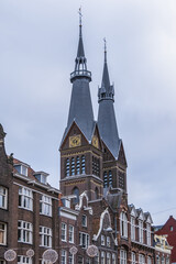 Neo-Gothic Post Horn Church (Posthoornkerk, 1863) with three slender towers on bustling Haarlemmerstraat - one of most important surviving nineteenth century churches. Amsterdam, the Netherlands.