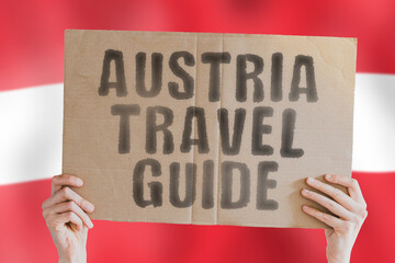 The phrase " Austria travel guide " on a banner in men's hand with blurred Austrian flag on the background. Worldwide. Terminal. Schedule. Relax. Opportunity. Planet. Knowledge. Learn. Flying