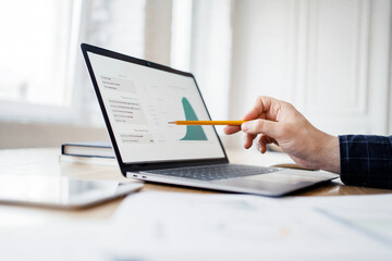 Uses laptop and fountain pen, businessman report in company office,