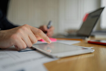 Fototapeta premium A businessman makes a report in the company's office, uses a laptop