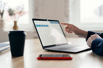 A businessman makes a report in the company's office, uses a laptop