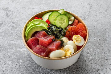 Paper box or package with tuna poke bowl salad with avocado for take away or food delivery