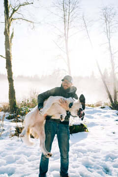 Cropped portrait of a man holding a squirming dog