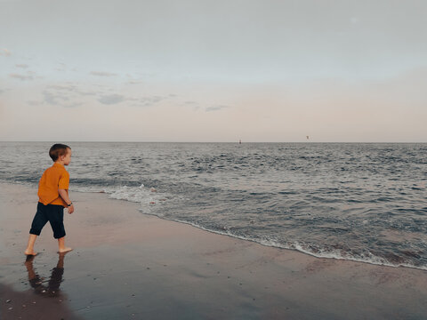 Little boy looks at the sea on the beach
