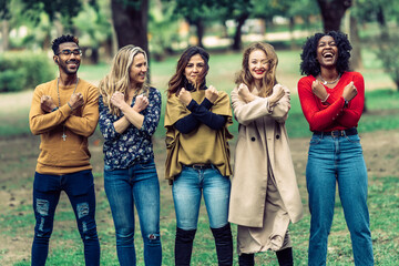 4 women and 1 man with arms crossed and fists clenched laughing