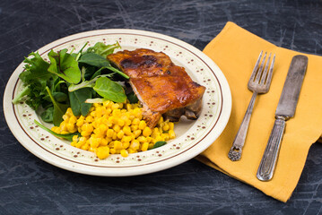 Fried pork with corn and lettuce on a plate. Healthy food concept