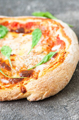 Freshly baked Italian pizza on a gray background. Close up.