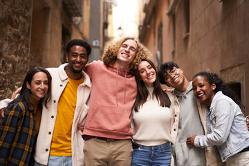 Portrait of a group of happy young students looking at the camera smiling. Concept of community and friendship