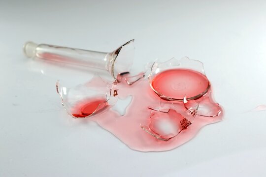 Broken laboratory glass, red liquid chemical spilled from laboratory glassware. Failed lab experiment. Chemical attempt.