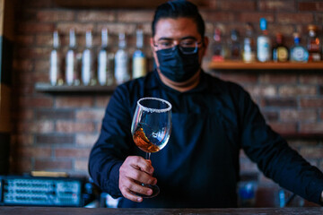 Bartender preparing a drink on a glass