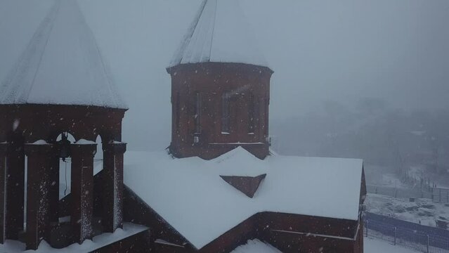 Aerial photography of the Armenian church in winter in a heavy snowstorm