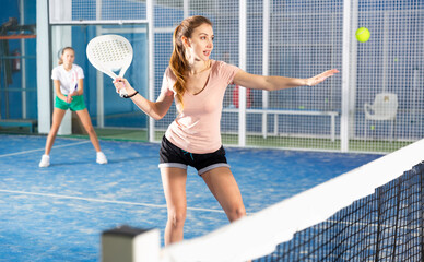 Portrait of an emotional young woman tennis player in padel tennis playing during a friendly doubles match on the court