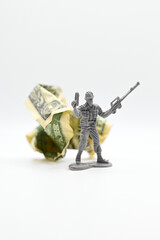 Plastic soldier with American dollars behind him.