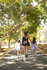 Fototapeta na wymiar mom and daughters walking in the park
