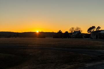Sunset over a farm field in a rural neighborhood