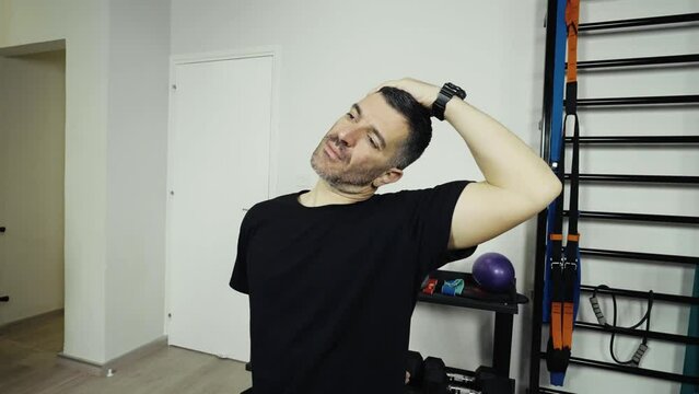 A man working out and stretching at a small home gym.