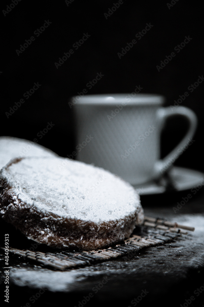 Poster A vertical shot of cookies with coconut flavor next to the coffee cup