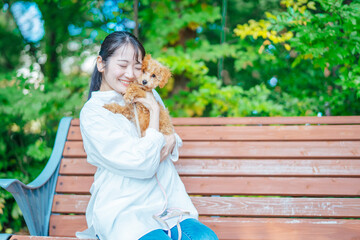 公園で犬と遊ぶ女性（抱く）
