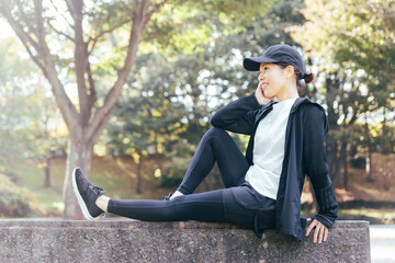 公園で休むスポーツウェアを着た女性
