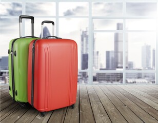 Modern stylish suitcases standing in empty airport hall, unrecognizable traveller's luggage