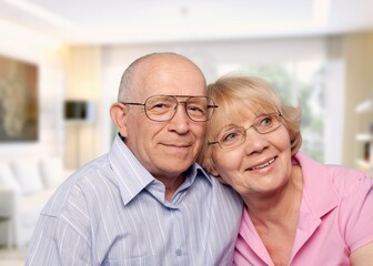 Smiling older couple hugging at home. Happy senior adult mature classy husband and wife