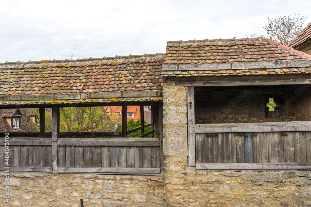 Poster Closeup of a vintage balcony with old roof tiles and weathered wooden fence