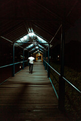 Person walking backwards on an old bridge