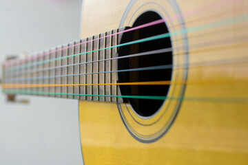 Obraz premium Portrait of an acoustic guitar body with colorful nylon strings