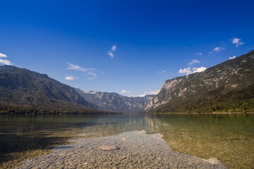 Panorama of Lake Bohinj, also called bohinjsko jezero, on a sunny afternoon. Bohinj lake is a major landmark of the Julian Alps mountain chain in Slovenia, Europe..