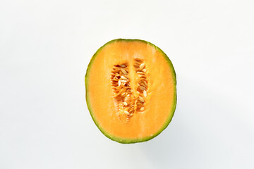 Top down view of a cross section of a cantaloupe isolated against white.