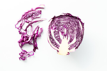 Cross section view of a purple cabbage with shavings of cabbage to the side.