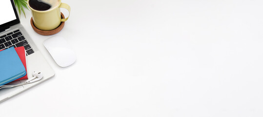 From above view laptop computer, wireless mouse, notebook and coffee cup on white table with copy...