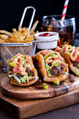 Cheeseburger tacos with fries and cola against a black background.
