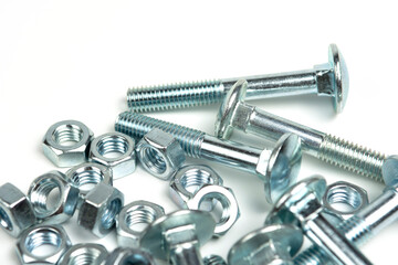 several silver metal bolts with nuts on a white background. close-up and copy space