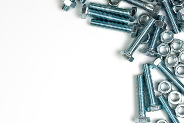 several silver metal bolts with nuts on a white background. close-up and copy space